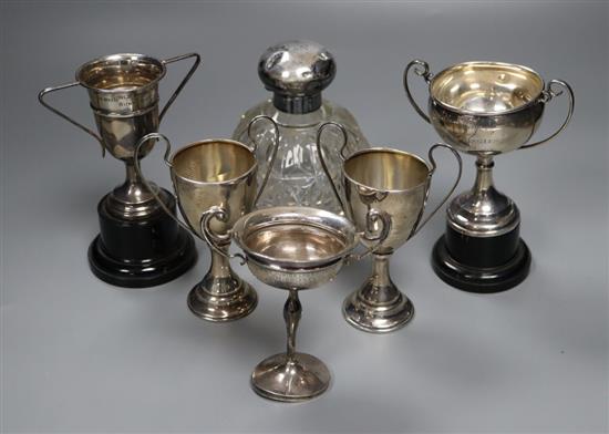 Five assorted small silver trophy cups, all with engraved inscriptions, tallest 12cm, and a silver mounted glass scent bottle.